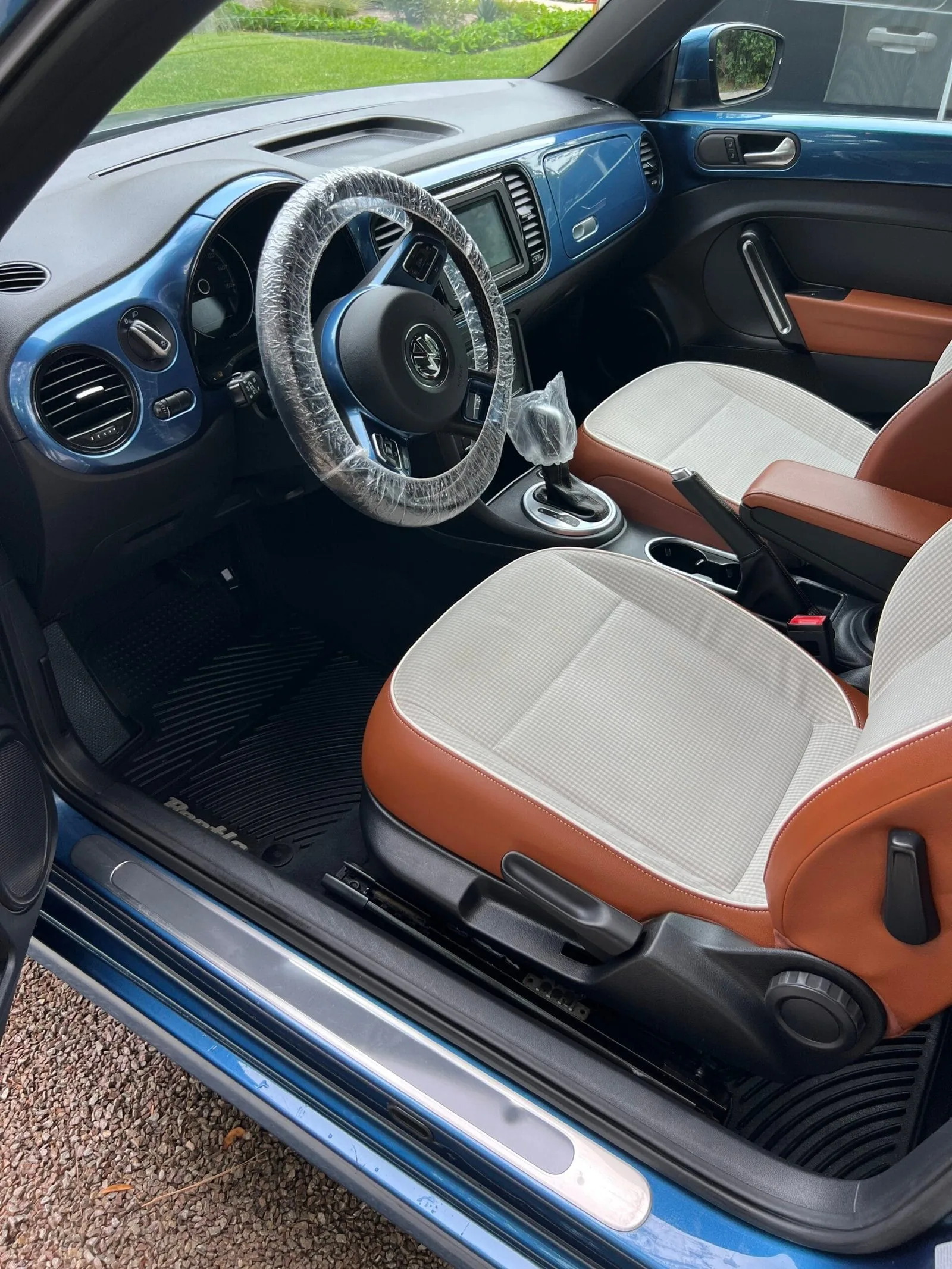 Clean interior of a blue Volkswagen Beetle after an Azul interior detail, cream and tan seats