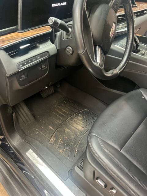 Cadillac Escalade driver's side before a Signature Interior Detail: floor mat caked with mud and grit
