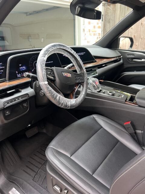 The same Cadillac Escalade after a Signature Interior Detail: clean floor mat, trim and leather seat