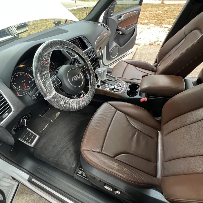 Audi Q5 interior after an Azul detail: brown leather seats and dashboard cleaned, steering wheel still wrapped in its protective cover