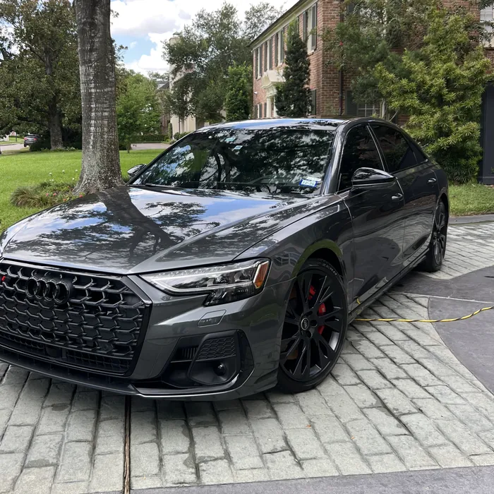 Gray Audi S8 after a detail, on a stone driveway under an oak tree