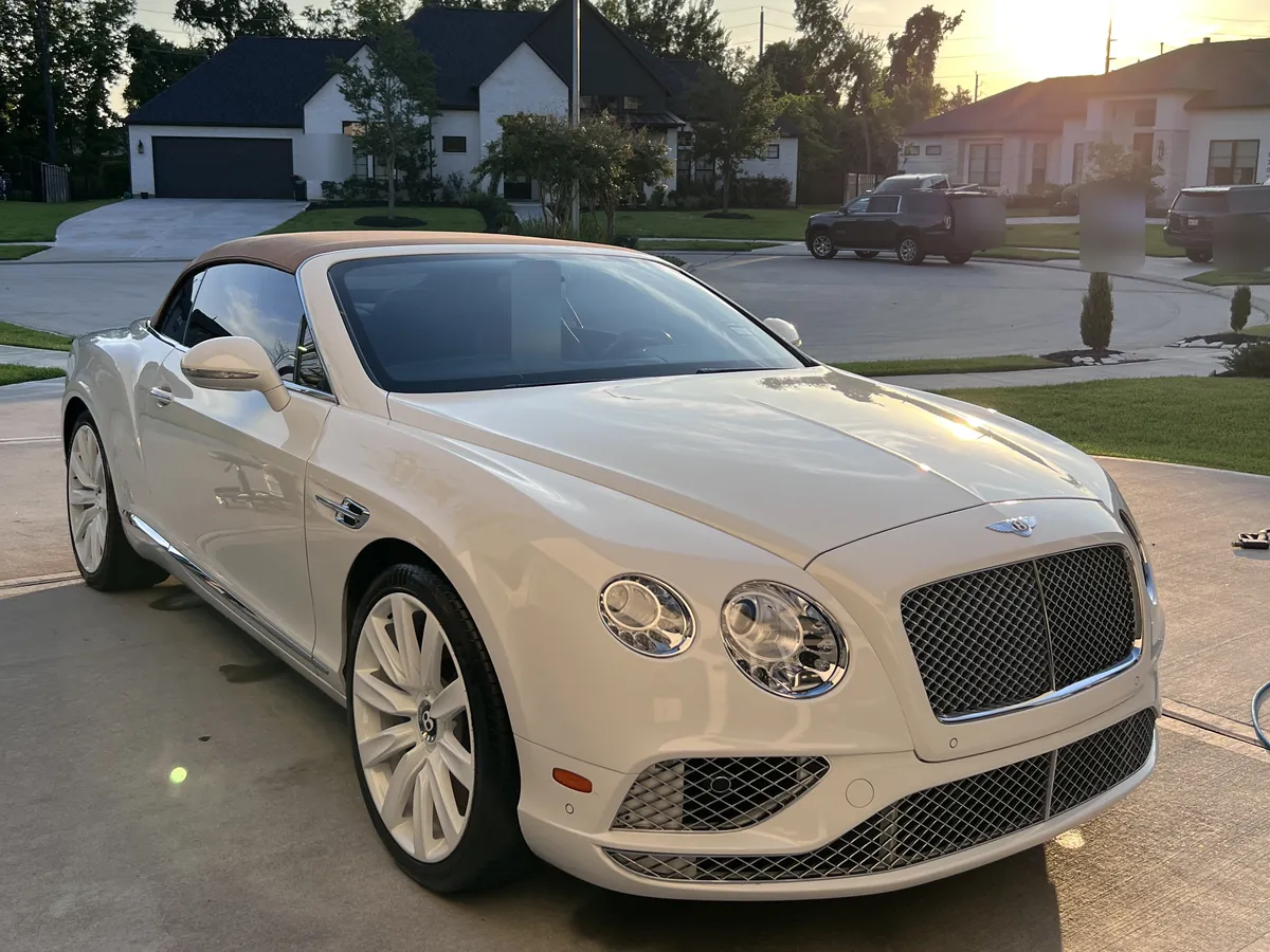 White Bentley Continental GTC convertible after an Azul detail, on a driveway in Sienna at sunset