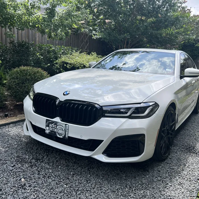 White BMW 5 Series after a detail, on a gravel driveway in the Houston Heights