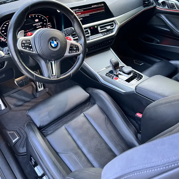 BMW M4 interior after an Azul detail: black leather seats, steering wheel and center console cleaned