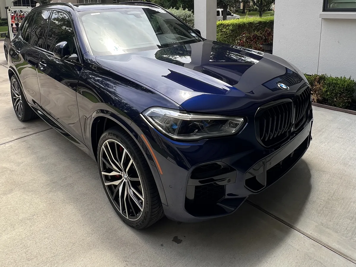 Dark blue BMW X5 after an Azul detail, in a West University Place driveway