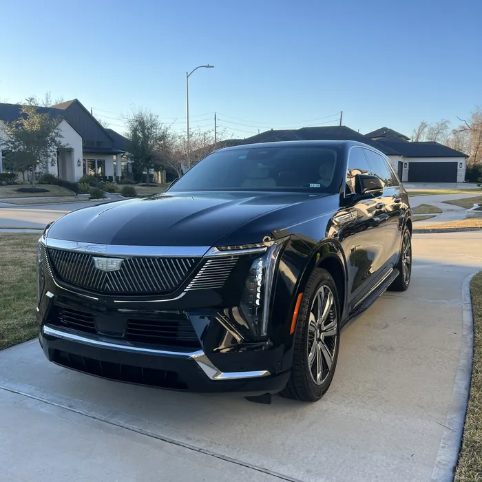 Black Cadillac Escalade IQ after a detail, on a driveway in Sienna