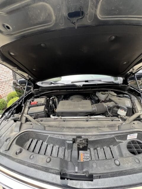 Before: Cadillac Escalade engine bay with dust and grime on the covers and cowl