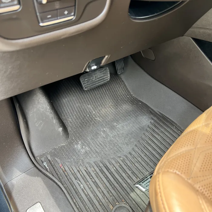 Cadillac Escalade driver floor mat before cleaning, covered in dirt and debris