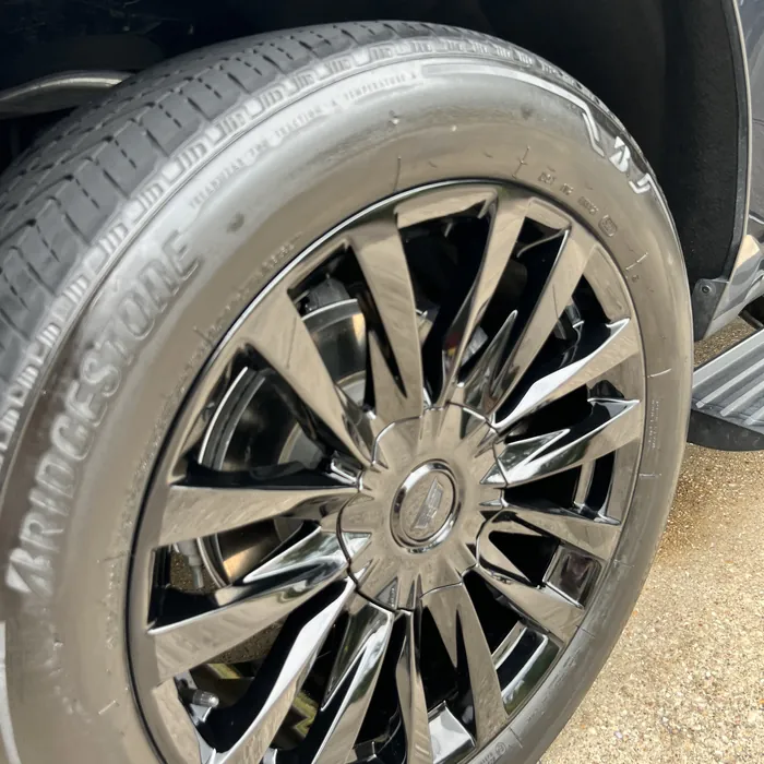The same Cadillac Escalade wheel after cleaning, glossy black