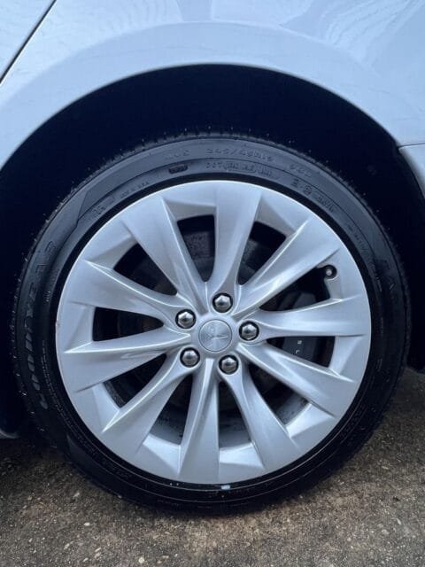 After: the same Tesla wheel clean, with a dressed tire