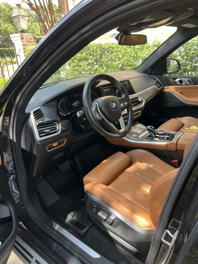 The same BMW X5 interior after the Full Detail: clean mat, trim and cognac leather seats