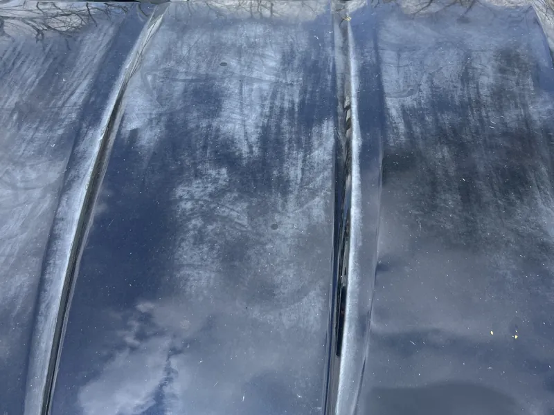 Dark blue Jaguar XK hood with hazy, patchy clear coat before correction