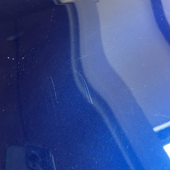 Light scratches on blue paint seen under an inspection light