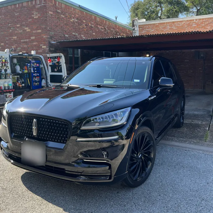 Black Lincoln Aviator after a detail, with the Azul van beside it