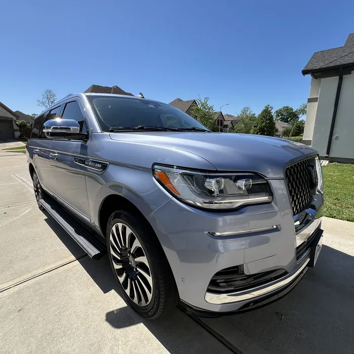 Silver-blue Lincoln Navigator after a detail, on a driveway in Sienna