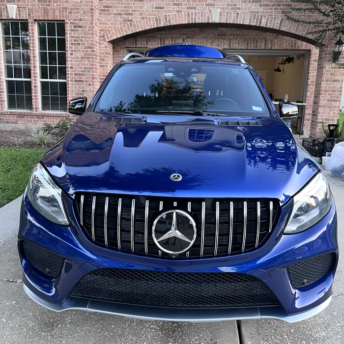 Blue Mercedes-AMG GLE after a detail, in front of a brick home