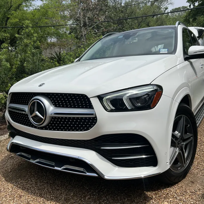 White Mercedes-Benz GLE after a detail, on a gravel driveway under trees in the Houston Heights