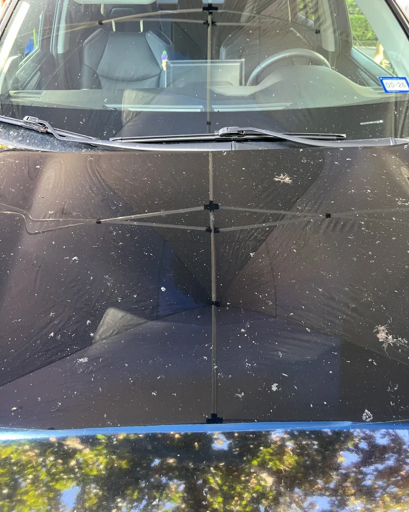 Black Toyota RAV4 hood under the Azul canopy on a Houston driveway, before correction