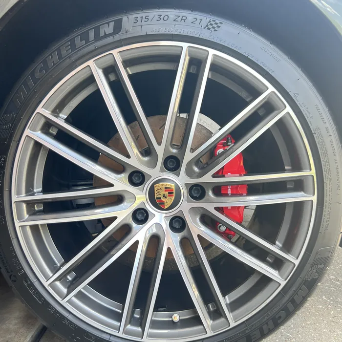 Porsche Panamera wheel and red brake caliper after cleaning