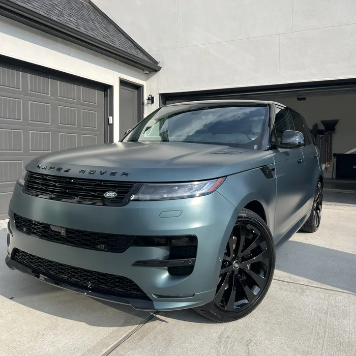 Satin green Range Rover Sport after a detail, in front of a garage in Sienna